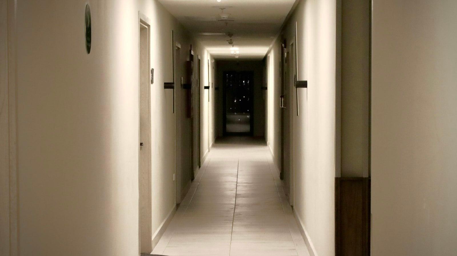 A long, dimly lit hallway with doors on both sides