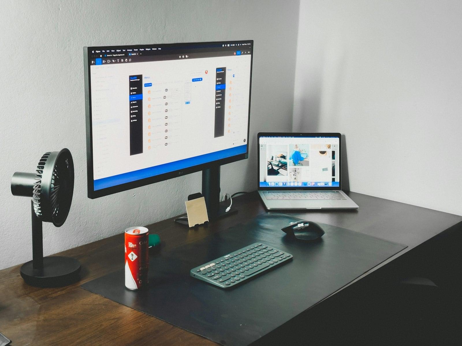 a laptop and a desktop computer on a desk